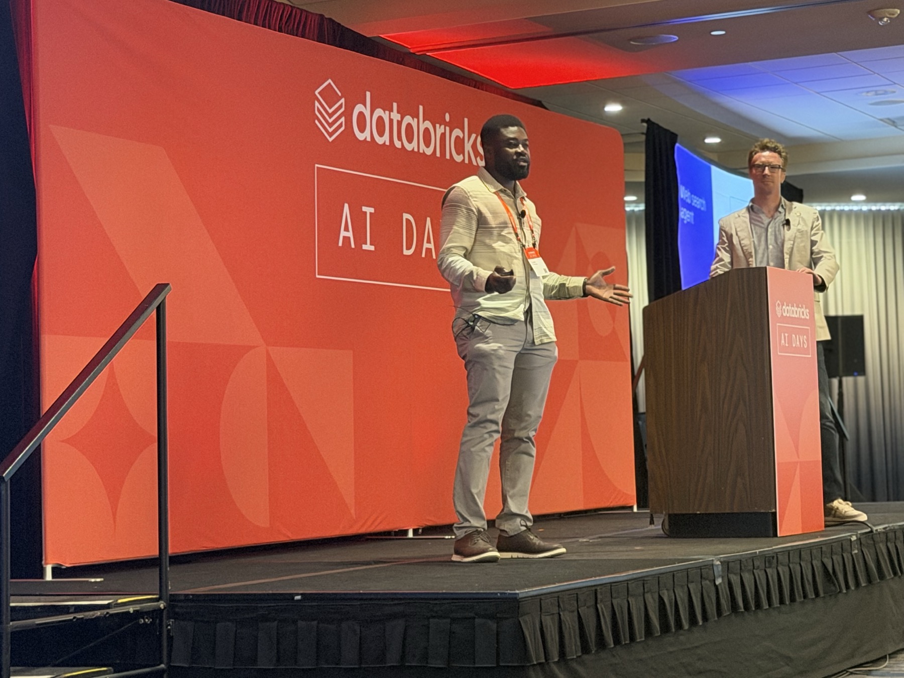 Ilyas Hassan presenting on stage at Databricks AI Days in Minneapolis